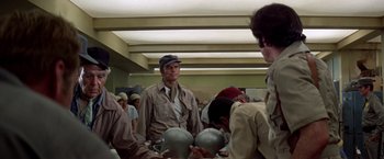 Movie still from “Soylent Green” (1973), directed by Richard Fleischer – A group of people standing around a room; Medium shot, Over the shoulder angle