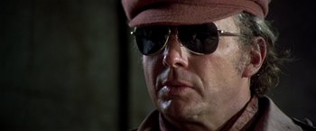 Movie still from “Soylent Green” (1973), directed by Richard Fleischer – A person wearing sunglasses and a hat; Close Up shot, Low angle