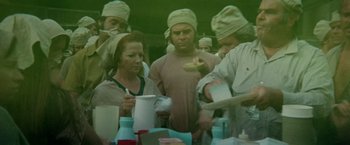 Movie still from “Soylent Green” (1973), directed by Richard Fleischer – A group of people standing around a table with food; Medium shot, High angle