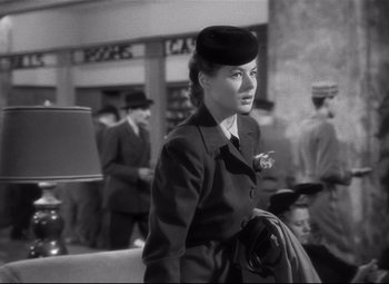 Movie still from “Spellbound” (1945), directed by Alfred Hitchcock – A woman wearing a hat and holding a cigarette in her mouth; Medium shot, Over the shoulder angle