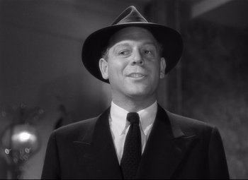 Movie still from “Spellbound” (1945), directed by Alfred Hitchcock – A black and white photo of a man in a suit and hat; Close Up shot, Low angle