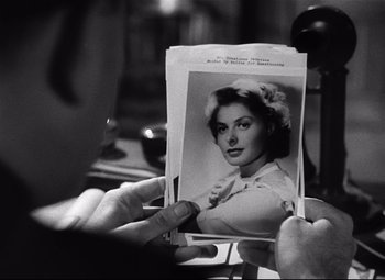 Movie still from “Spellbound” (1945), directed by Alfred Hitchcock – An old photo of a young woman in a dress; Close Up shot, Over the shoulder angle