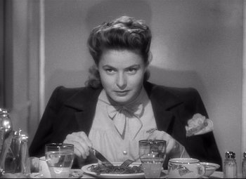 Movie still from “Spellbound” (1945), directed by Alfred Hitchcock – A woman sitting at a table with a plate of food in front of her; Close Up shot, Over the shoulder angle