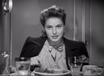 Movie still from “Spellbound” (1945), directed by Alfred Hitchcock – A woman sitting at a table with a plate in front of her; Close Up shot, Over the shoulder angle