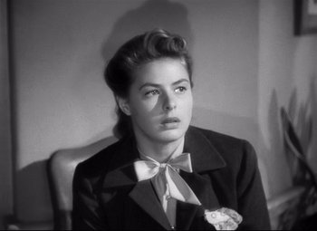 Movie still from “Spellbound” (1945), directed by Alfred Hitchcock – A black and white photo of a woman in a suit and bow tie; Close Up shot, Over the shoulder angle