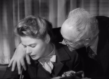Movie still from “Spellbound” (1945), directed by Alfred Hitchcock – An older man and a younger woman embracing each other; Close Up shot, High angle