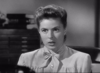 Movie still from “Spellbound” (1945), directed by Alfred Hitchcock – A black and white photo of a woman with a bow tie; Close Up shot, Low angle