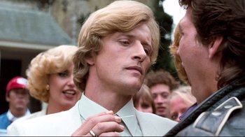 Movie still from “Spetters” (1980), directed by Paul Verhoeven – A person tying a tie; Close Up shot, Over the shoulder angle