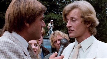 Movie still from “Spetters” (1980), directed by Paul Verhoeven – A man is being interviewed by another man; Close Up shot, Low angle
