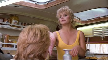 Movie still from “Spetters” (1980), directed by Paul Verhoeven – A woman in a yellow top is looking at another woman in a yellow dress; Medium shot, Over the shoulder angle