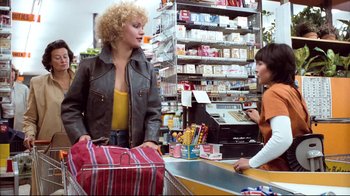 Movie still from “Spetters” (1980), directed by Paul Verhoeven – A woman is talking to a woman in a store; Medium shot, Low angle