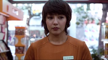 Movie still from “Spetters” (1980), directed by Paul Verhoeven – A woman in an orange shirt is looking at the camera; Close Up shot, Low angle