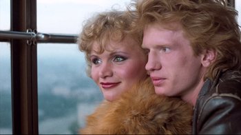 Movie still from “Spetters” (1980), directed by Paul Verhoeven – A man and a woman posing for a picture; Close Up shot, Low angle
