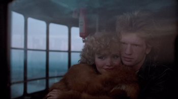 Movie still from “Spetters” (1980), directed by Paul Verhoeven – A man and a woman are hugging in a room; Close Up shot, Low angle