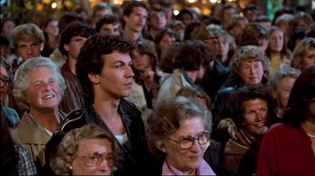 Movie still from “Spetters” (1980), directed by Paul Verhoeven – A group of people standing in a room; Medium shot, High angle