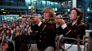 Movie still from “Spetters” (1980), directed by Paul Verhoeven – Two men in military uniforms playing their instruments; Medium shot, Low angle