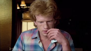 Movie still from “Spetters” (1980), directed by Paul Verhoeven – A young man holding a nintendo wii controller in his hand; Close Up shot, Over the shoulder angle