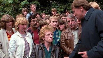 Movie still from “Spetters” (1980), directed by Paul Verhoeven – A group of people standing in front of each other; Medium shot, Over the shoulder angle