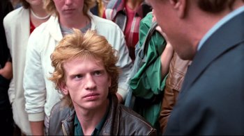 Movie still from “Spetters” (1980), directed by Paul Verhoeven – A man with blonde hair and a brown leather jacket; Close Up shot, Over the shoulder angle