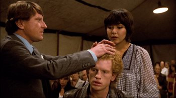 Movie still from “Spetters” (1980), directed by Paul Verhoeven – A man getting his hair cut by a woman; Medium shot, Over the shoulder angle