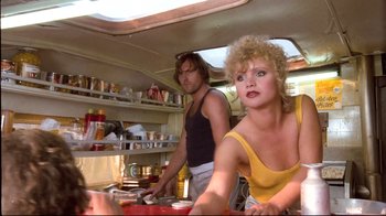 Movie still from “Spetters” (1980), directed by Paul Verhoeven – A man and a woman in a kitchen; Medium shot, Low angle