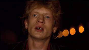 Movie still from “Spetters” (1980), directed by Paul Verhoeven – A young man with red hair is looking at the camera; Close Up shot, Low angle