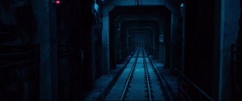 Movie still from “Spiral” (2021), directed by Darren Lynn Bousman – A train track in the middle of an underground tunnel; Extreme Wide shot, High angle