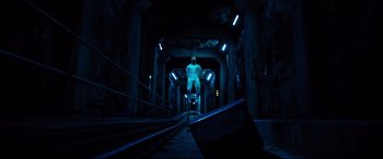 Movie still from “Spiral” (2021), directed by Darren Lynn Bousman – A man standing on a train track in the dark; Wide shot, Low angle