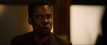 Movie still from “Spiral” (2021), directed by Darren Lynn Bousman – A person wearing a suit and tie; Close Up shot, Over the shoulder angle