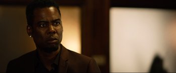 Movie still from “Spiral” (2021), directed by Darren Lynn Bousman – A person wearing a suit and tie; Close Up shot, Over the shoulder angle