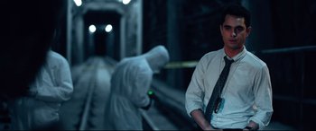 Movie still from “Spiral” (2021), directed by Darren Lynn Bousman – A man standing next to a person in a white suit; Medium shot, Over the shoulder angle