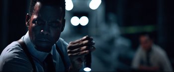 Movie still from “Spiral” (2021), directed by Darren Lynn Bousman – A man holding a cigarette in his hands; Close Up shot, Low angle