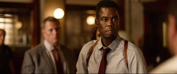 Movie still from “Spiral” (2021), directed by Darren Lynn Bousman – A man in a white dress shirt and red tie; Close Up shot, Over the shoulder angle