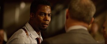 Movie still from “Spiral” (2021), directed by Darren Lynn Bousman – A man wearing a suit and tie talking to another man wearing a suit and tie; Close Up shot, Over the shoulder angle