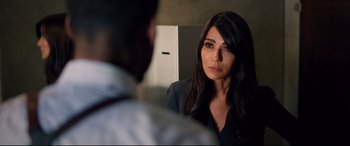 Movie still from “Spiral” (2021), directed by Darren Lynn Bousman – A woman in a suit looking at a man in a dress shirt; Close Up shot, Over the shoulder angle