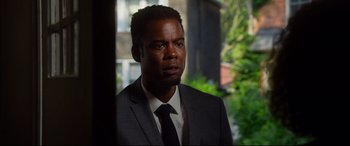 Movie still from “Spiral” (2021), directed by Darren Lynn Bousman – A man in a suit and tie looking out a window; Close Up shot, Over the shoulder angle