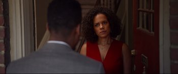 Movie still from “Spiral” (2021), directed by Darren Lynn Bousman – A woman in a red dress looking at a man in a gray suit; Close Up shot, Over the shoulder angle