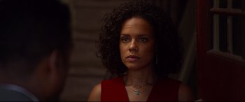 Movie still from “Spiral” (2021), directed by Darren Lynn Bousman – A woman in a red dress is looking at the camera; Close Up shot, Over the shoulder angle