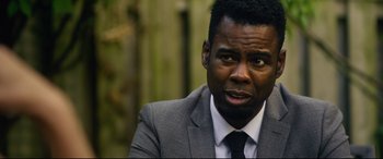 Movie still from “Spiral” (2021), directed by Darren Lynn Bousman – A man wearing a suit and tie looking at the camera; Close Up shot, Over the shoulder angle