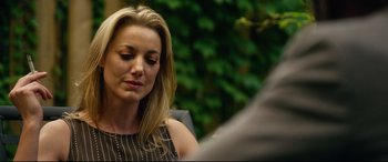 Movie still from “Spiral” (2021), directed by Darren Lynn Bousman – A woman sitting in front of a tree; Close Up shot, Over the shoulder angle