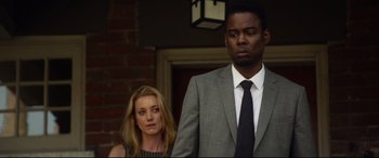 Movie still from “Spiral” (2021), directed by Darren Lynn Bousman – A man and a woman standing next to each other in front of a brick wall; Medium shot, Over the shoulder angle