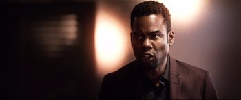 Movie still from “Spiral” (2021), directed by Darren Lynn Bousman – A person wearing a suit and tie; Close Up shot, Over the shoulder angle