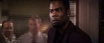 Movie still from “Spiral” (2021), directed by Darren Lynn Bousman – A person wearing a suit and tie; Close Up shot, Over the shoulder angle