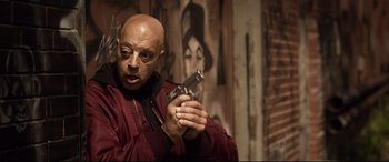 Movie still from “Spiral” (2021), directed by Darren Lynn Bousman – A man holding a gun in his hands; Close Up shot, Low angle