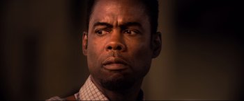 Movie still from “Spiral” (2021), directed by Darren Lynn Bousman – A man's face with a serious look; Close Up shot, Over the shoulder angle