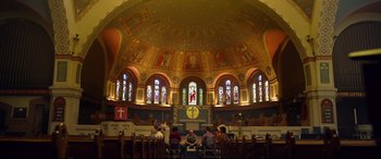 Movie still from “Spiral” (2021), directed by Darren Lynn Bousman – A group of people sitting in front of an altar; Extreme Wide shot, High angle