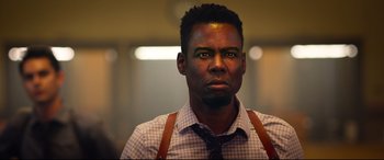 Movie still from “Spiral” (2021), directed by Darren Lynn Bousman – A man wearing a plaid shirt and brown suspenders; Close Up shot, Low angle