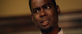 Movie still from “Spiral” (2021), directed by Darren Lynn Bousman – A man's face looking at the camera; Close Up shot, Low angle