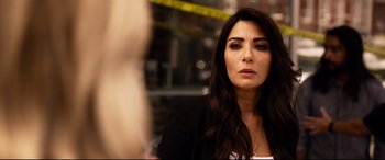 Movie still from “Spiral” (2021), directed by Darren Lynn Bousman – A woman in a black jacket is looking at the camera; Close Up shot, Over the shoulder angle