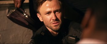 Movie still from “Spiral” (2021), directed by Darren Lynn Bousman – A person wearing a police uniform; Close Up shot, Over the shoulder angle